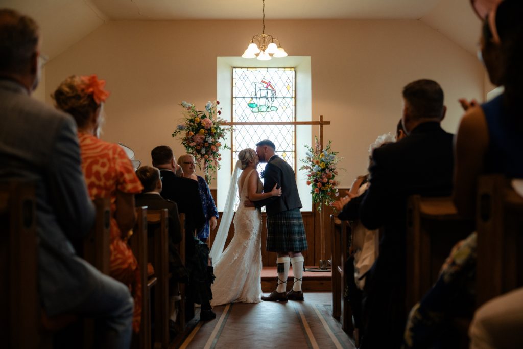 bride + groom in front of arch at Glen Clova Kirk