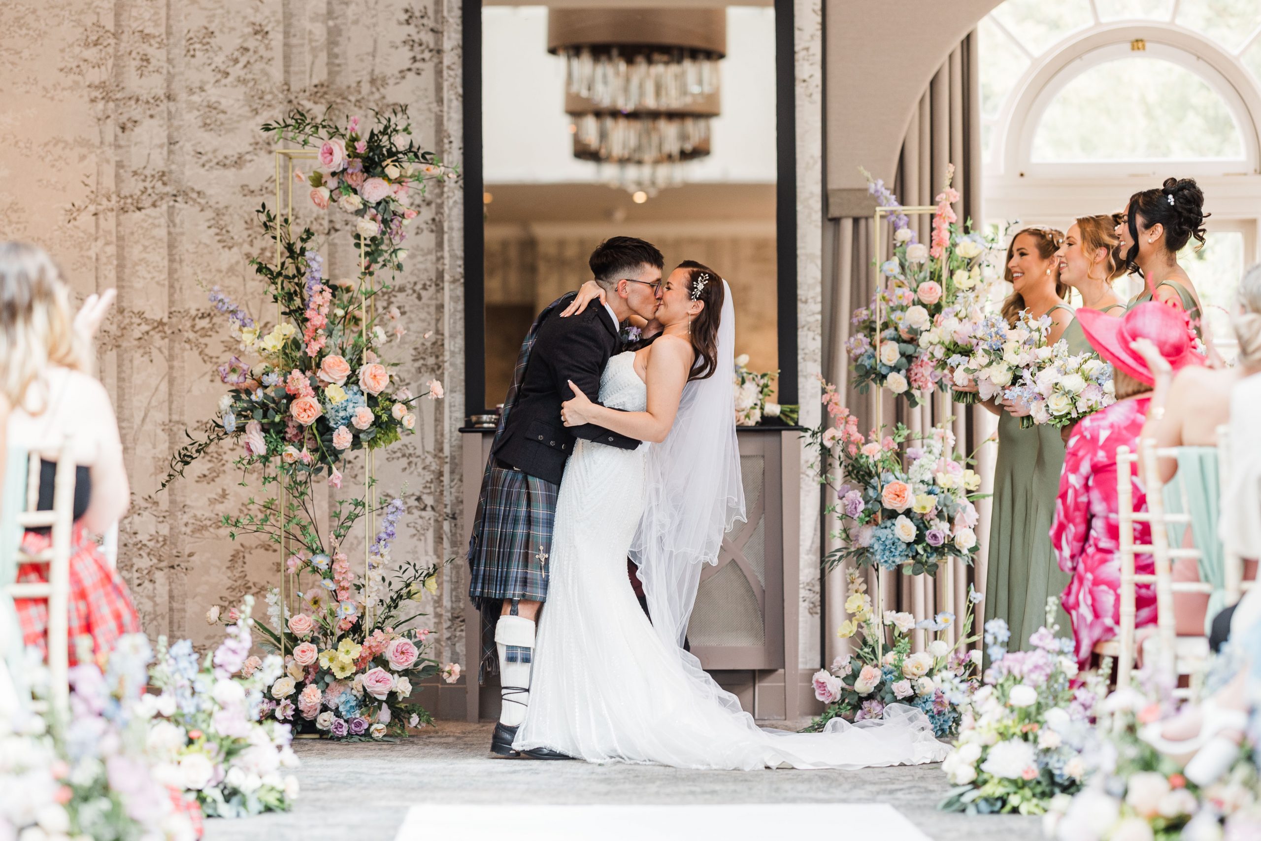Wedding Flowers. Bride & Groom standing next to floral columns at Balbirnie House