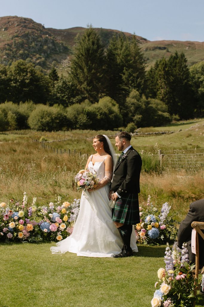bride + groom in front of floral ground arch