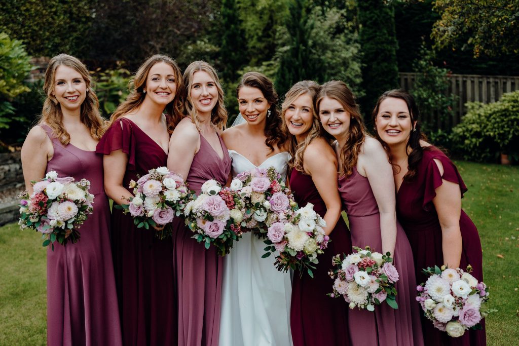 bridal party holding mauve + burgundy bouquets at Errol park