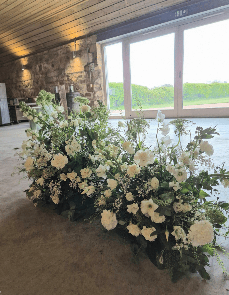 garden style ground arch with white seasonal flowers