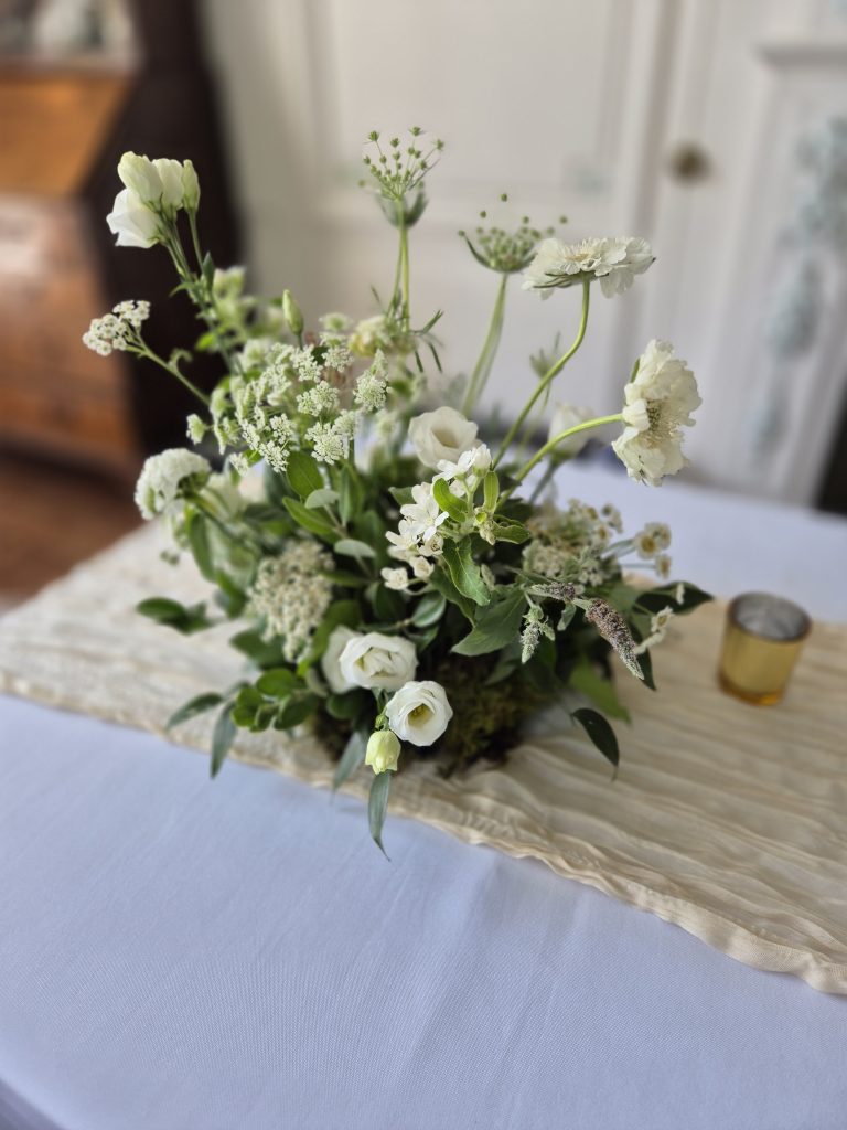 kinblethmont-house-wedding-angus-2 - Fraoch Floral Design White and pale-green bouquet as a table centerpiece with a light runner and soft-focus background