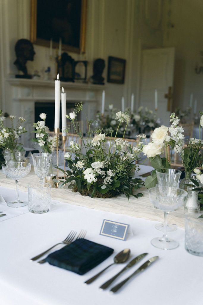 kinblethmont-house-wedding-angus-fraoch-floral-design 16 - Fraoch Floral Design Elegant dining table with white flowers, candles, and crystal glassware for a formal event or wedding reception.