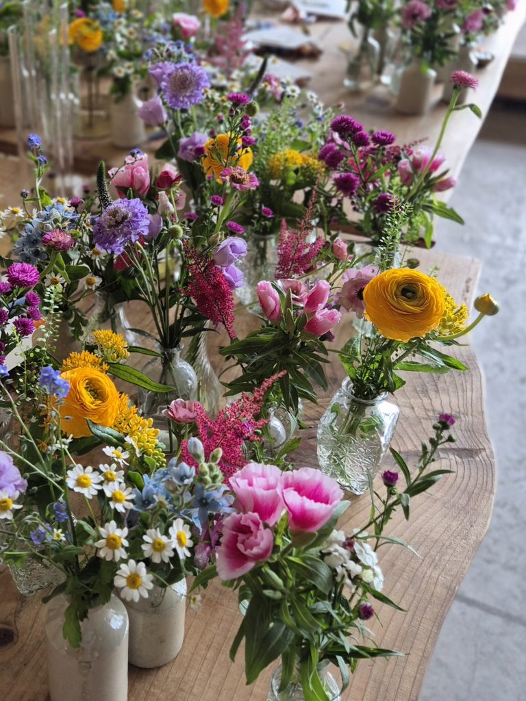 boreland-loch-tay-wedding-fraoch-floral-design 11 - fraoch floral design fraoch floral design colorful flower bouquets in glass vases arranged along a wooden table
